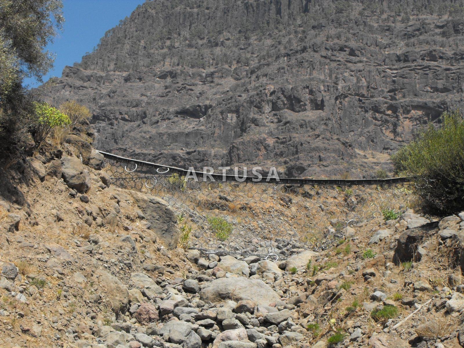 Debris flow barrier in a torrent channel
